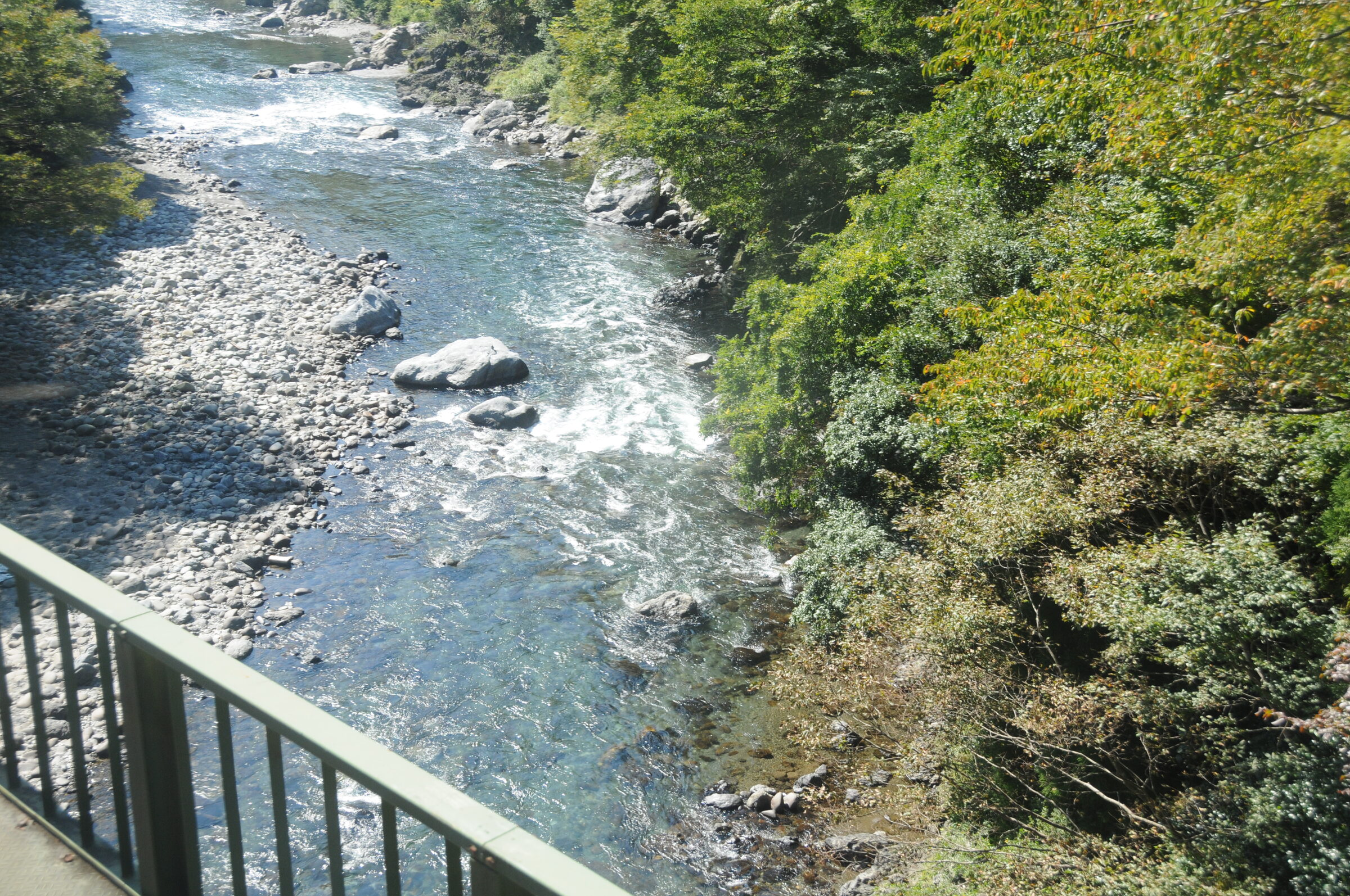 道路橋の赤い斜材ごしに見た、根尾川を渡る樽見鉄道の鉄橋